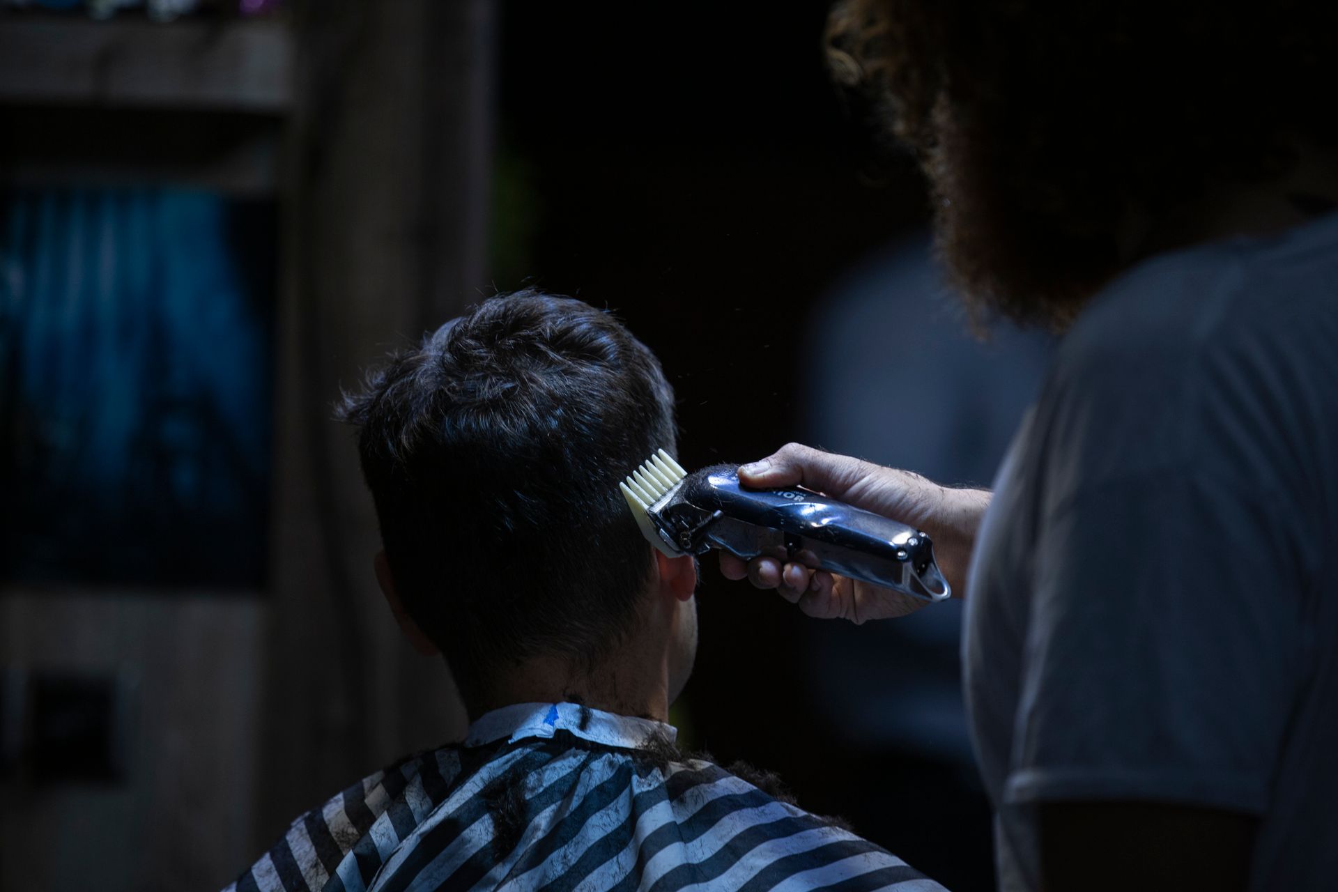 Professional barber performing a detailed fade at Apex Barbershop Studio